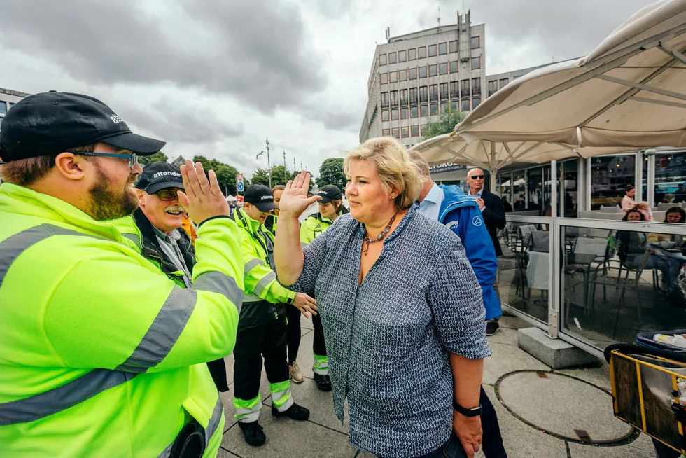 Ingebrigt Valsvik Gjerde fra prosjektet «Ren by» i Stavanger gir statsminister Erna Solberg en high-five på fisketorget. Nå vil statsministeren ha enda flere ut i jobb. Foto: Johannes Worsøe Berg