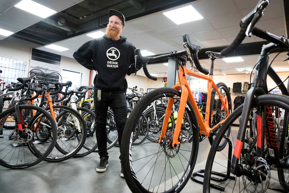 Daglig leder Jonas Strømberg hos Sørensen Sykler mener den oransje «tre i én»-sykkelen er løsningen for mange syklister. Man kan sette den opp som en ren landeveissykkel, en grusracer eller som en hardtail terrengsykkel med bukkestyre. Foto: Gunnar Lier