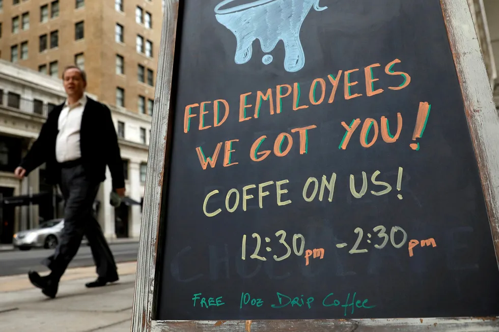 En arbeider passerer en café som mandag tilbød gratis kaffe til offentlig ansatte i Washington. Foto: Kevin Lamarque/Reuters