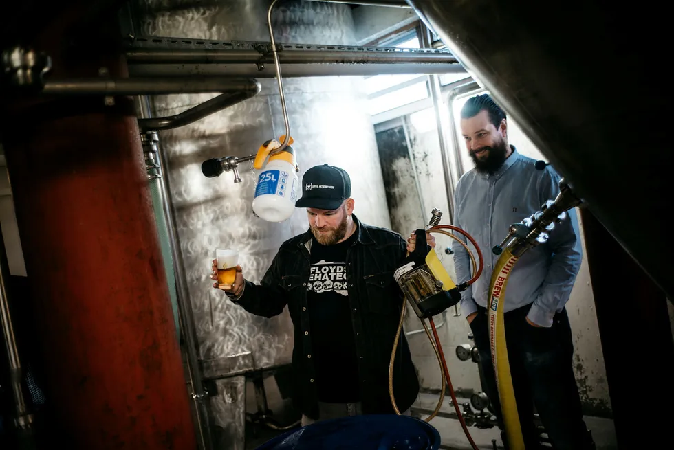Daglig leder i Lervig Aktiebryggeri Anders Kleinstrup, til høyre, og bryggerimester Mike Murphy inspiserer en prøve fra en av tankene. Foto: Tommy Ellingsen