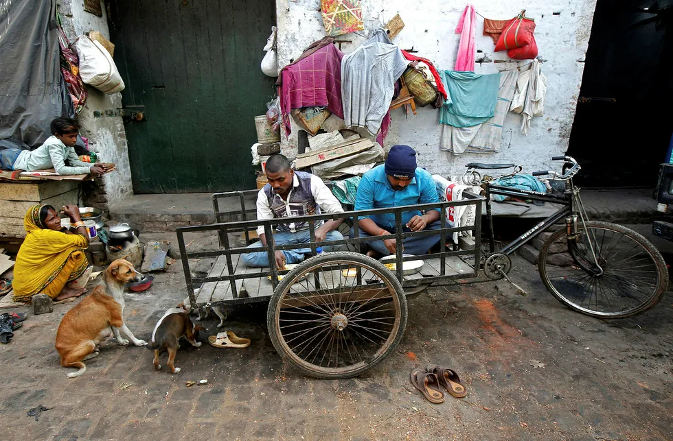 To "sykkelbud" i Kolkata i India spiser mat ved sitt midlertidlige hjem. India er et av landene som ventes å bidra med høy vekst det kommende året. Foto: Rupak de Chowdhuri/Reuters/NTB Scanpix