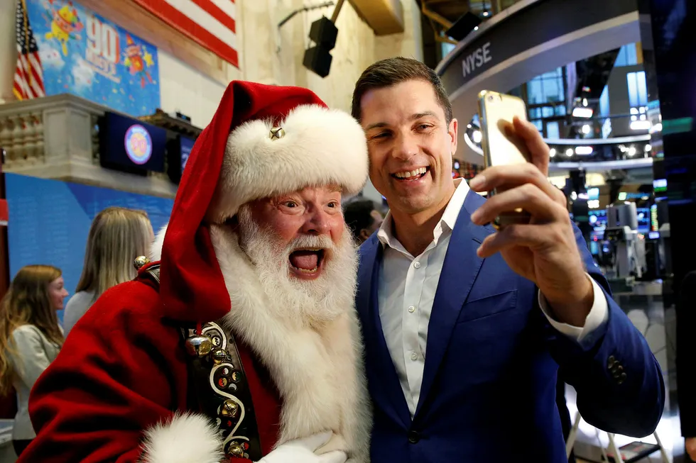 Toppsjef for New York-børsen, Tom Farley, poserer for en selfie med varehuset Macy's' julenisse. Julenissen fikk æren av å ringe åpningsklokken da børsen åpnet Thanksgiving-helgen onsdag. Foto: BRENDAN MCDERMID/Reuters