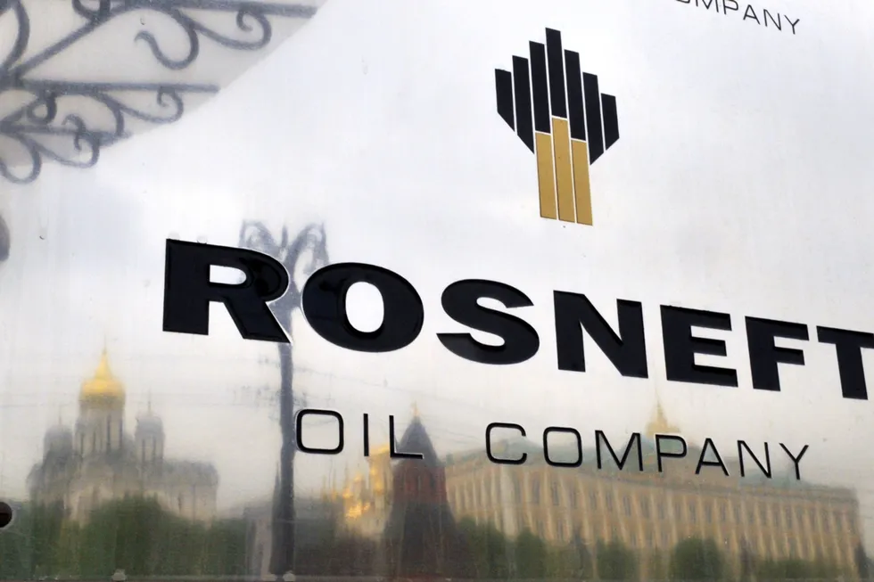 Dealings: Kremlin's churches and towers reflected in the company plate at an entrance to headquarters of Russian oil producer Rosneft in Moscow