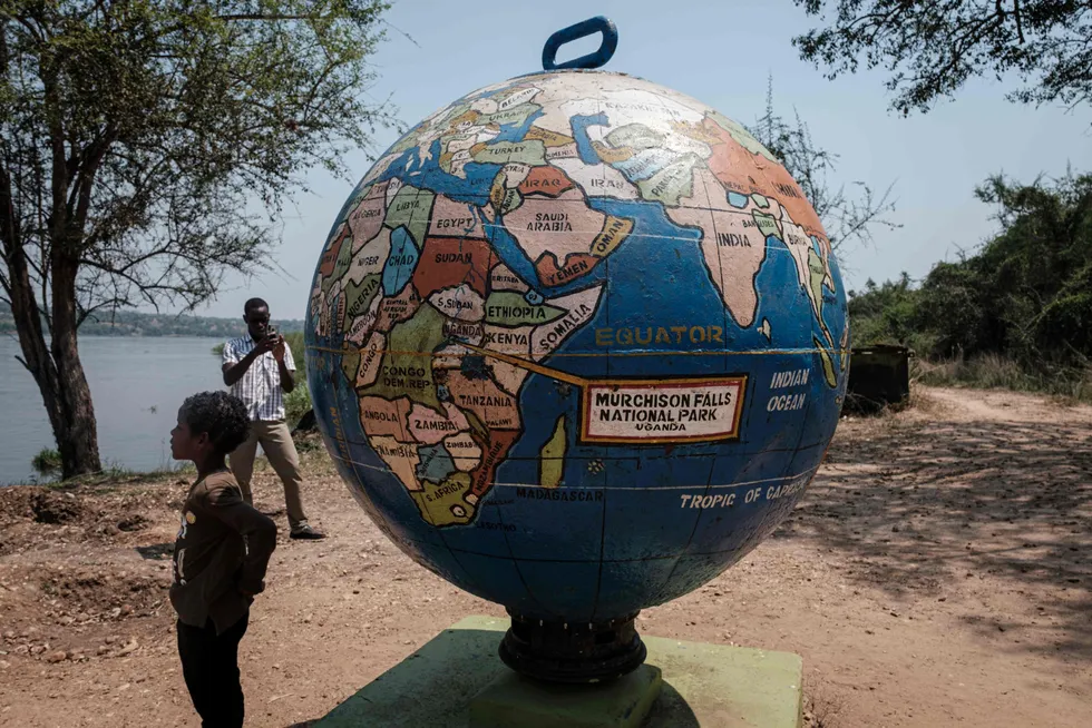 Another world: a boy stands next to a model globe at the Murchison Falls National Park in Uganda, close to where oil is due to start flowing in 2025