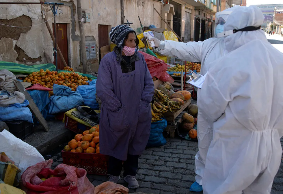 En fruktselger på et marked i El Alto i Bolivia testes for koronaviruset.
