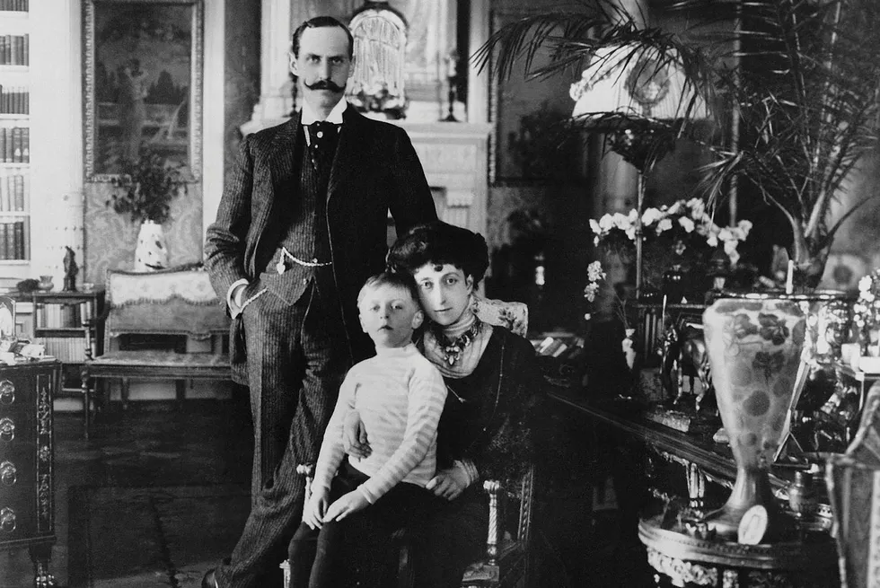 Haakon, Maud og lille Olav fotografert i 1909. Rundt dem er praktfulle og dyrebare gjenstander Maud arvet fra den britiske kongefamilien hun var en del av.