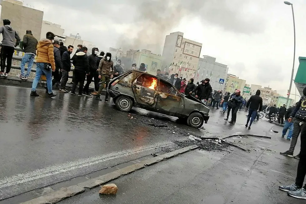 Growing discontent: Iranian protesters surround a burning car during a demonstration against an increase in gasoline prices in the capital Tehran