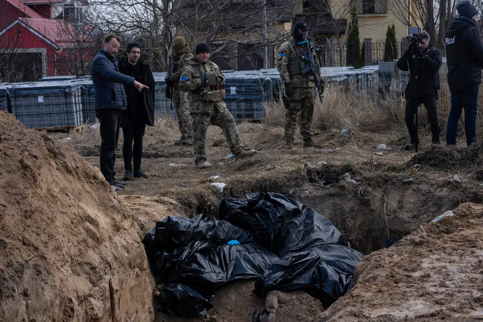 Mennesker står ved en massegrav i Butsja, i utkanten av den ukrainske hovedstaden Kyiv. Russland møter en ny bølge med fordømmelser etter at bevis har kommet frem som ser ut til å peke mot bevisst likvidering av opptil flere hundre sivile i Ukraina.