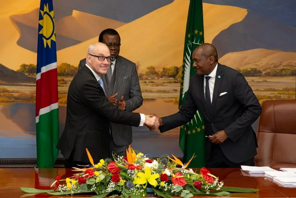 Marco Raffinetti, CEO of Hyphen Hydrogen Energy, left, shakes hands with an unidentified official after signing the agreement on Friday, as Namibian President Hage Geingob looks on.