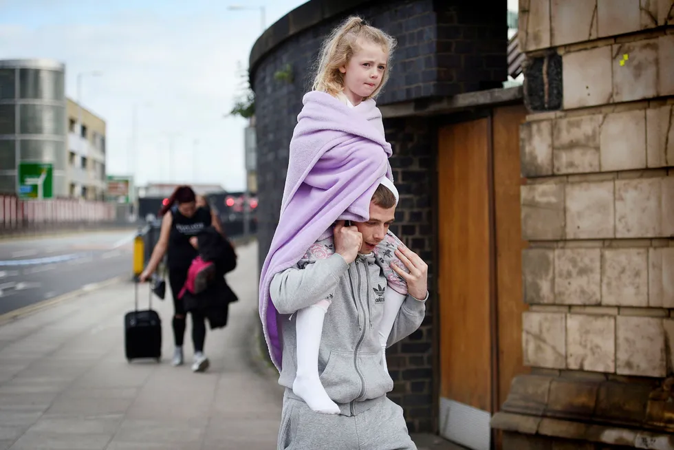 En mann bærer en ung jente på skuldrene nær Victoria station i Manchester dagen etter bombeangrepet ved Manchester Arena mandag kveld. Angrepet er det verste på over ti år i Storbritannia. Landets statsminister Theresa May sier i en pressemelding at politiet behandler eksplosjonen som et terrorangrep. OLI SCARFF/AFP/NTB scanpix