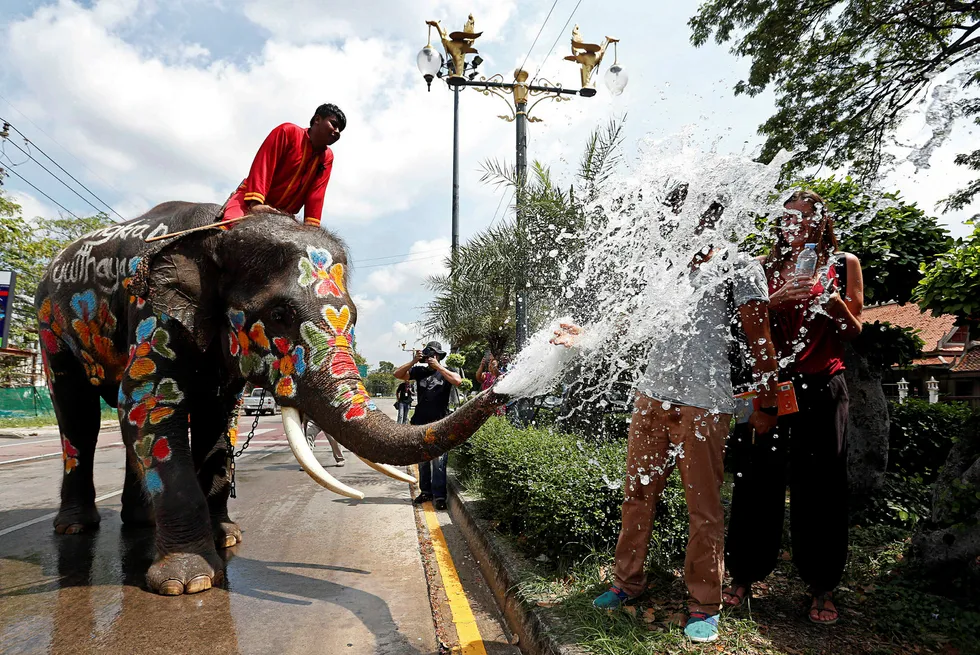 En elefant dynker turister med vann under en vannfestival nord for Bangkok i Thailand Foto: Chaiwat Subprasom/Reuters/NTB scanpix