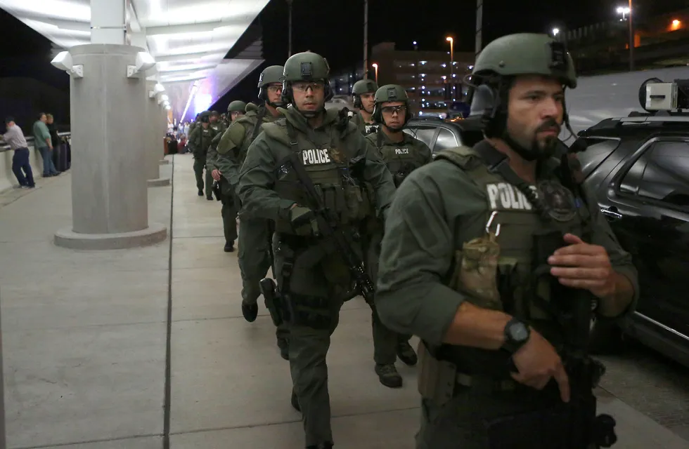 Politiet eskorterte flypassasjerer ut av flyplassen på Fort Lauderdale etter skytingen fredag. Foto: TNS/ABACA