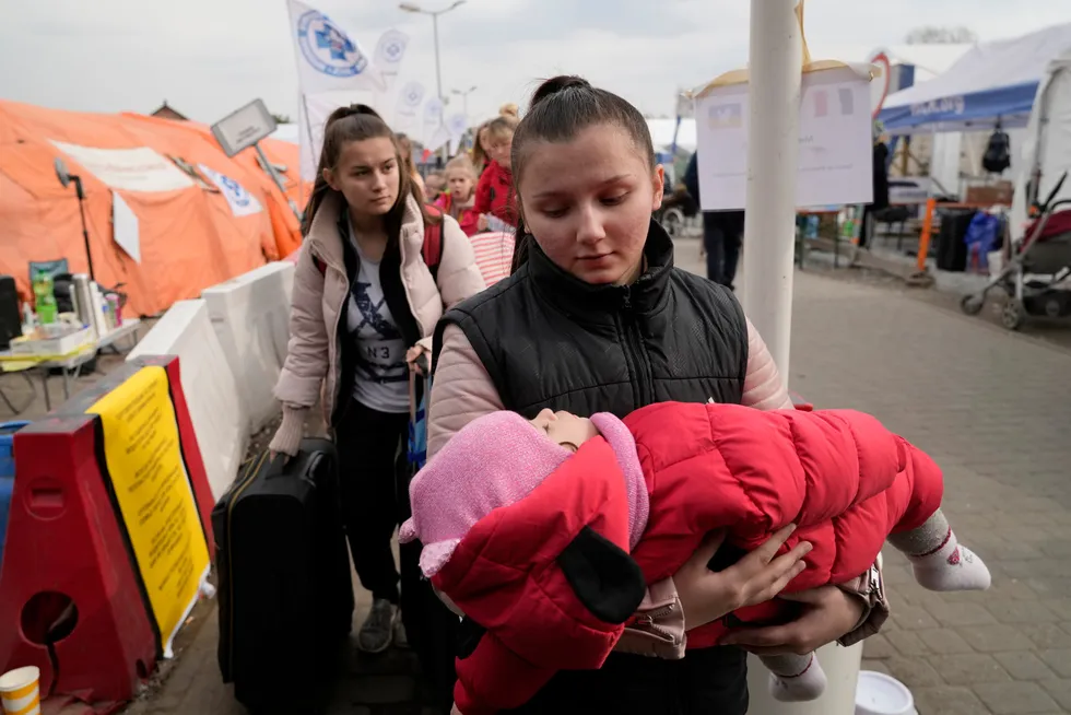 En flyktning, bærende på en baby, ankommer fra Ukraina til Polen ved grensestasjonen Medyka tirsdag.