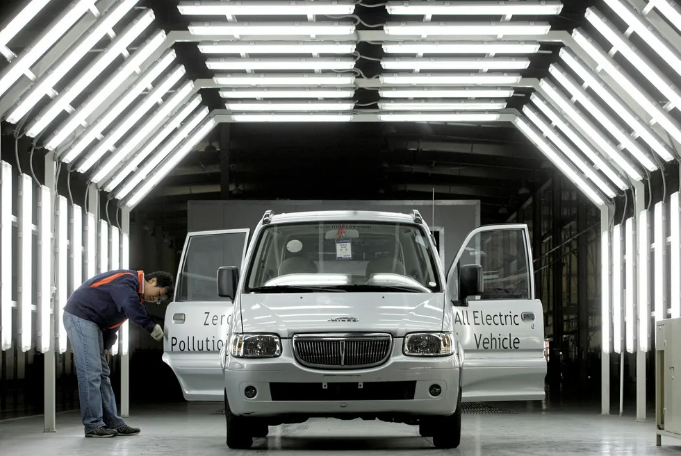 Gearing up: an employee inspects an electric car produced at a factory in Tianjin, China