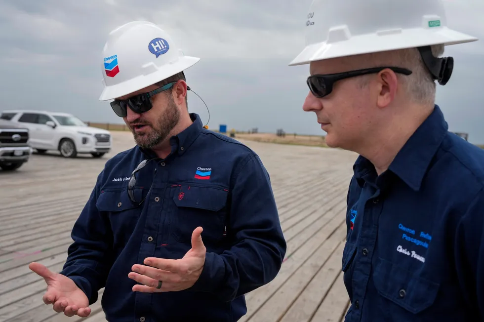 Chevron drilling manager Josh Fink (left) discusses the standard drill rig that will drill the first onshore test well for the Bayou Bend project, while Chris Powers (right), vice president of CCUS for Chevron, looks on.