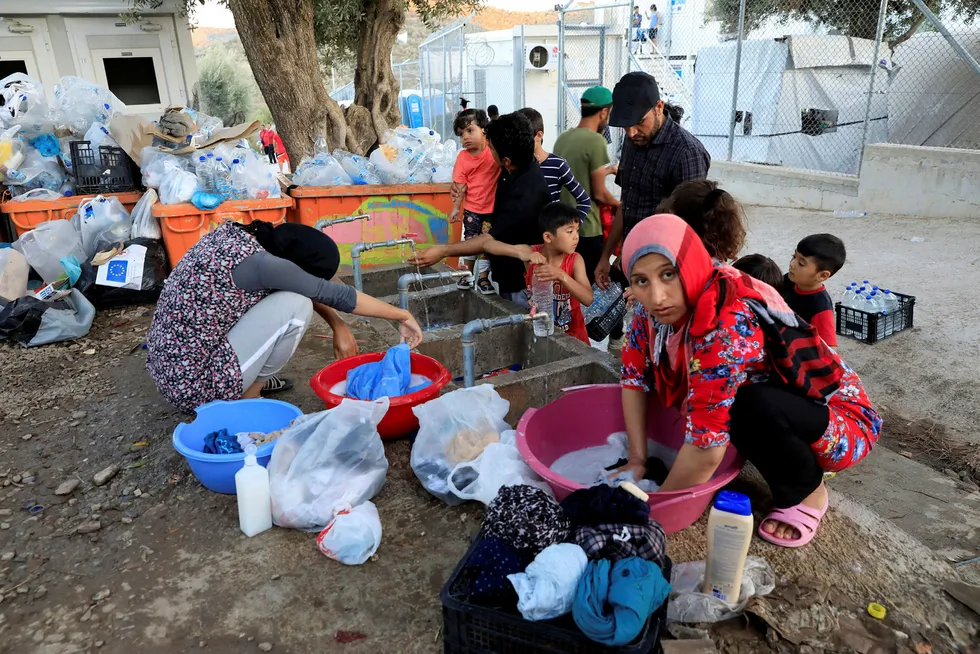 Migrants wash their clothes and fill bottles with water at a makeshift camp next to the Moria camp for refugees and migrants on the island of Lesbos, Greece, September 18, 2018. Picture taken September 18, 2018. REUTERS/Giorgos Moutafis ---