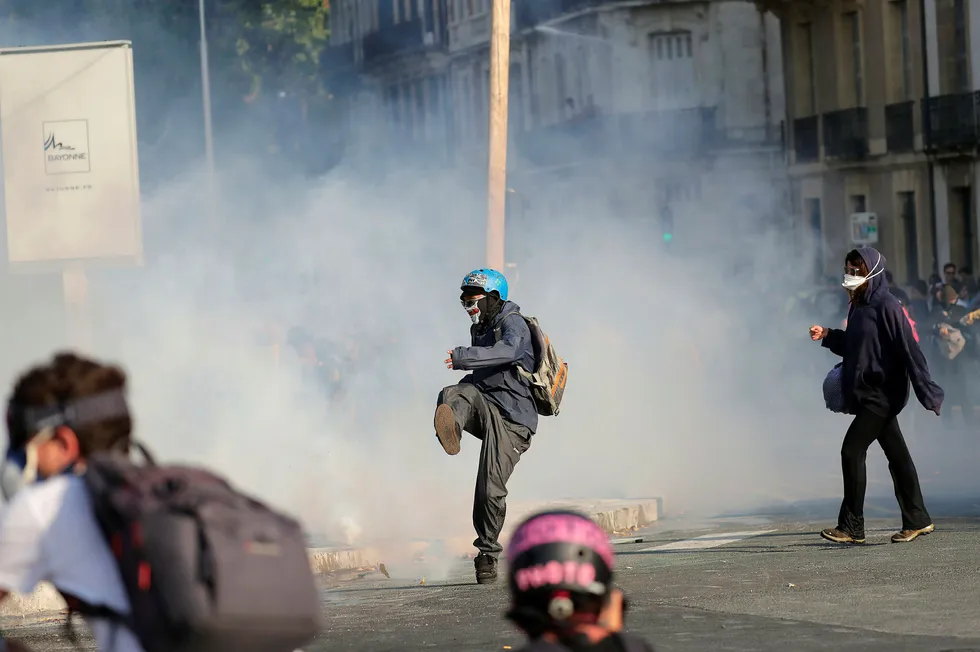 En demonstrant sparker vekk en tåregassflaske kastet av politiet i Bayonne i Frankrike lørdag.