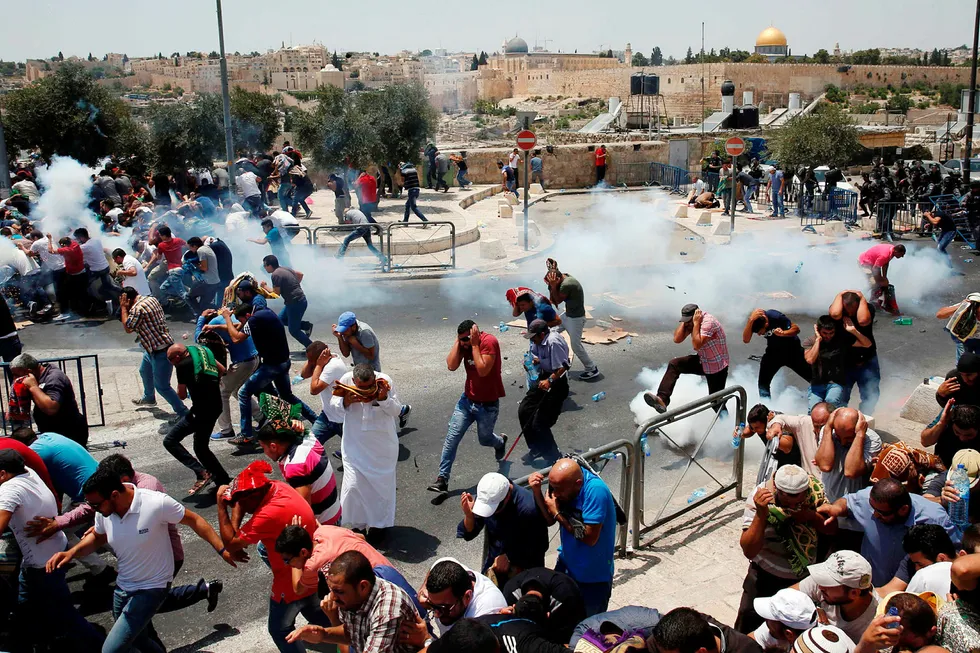 Palestinere løper unna tåregass avfyrt av israelske styrker etter bønn utenfor gamlebyen i Jerusalem. Foto: Ahmad Gharabli/AFP/NTB Scanpix