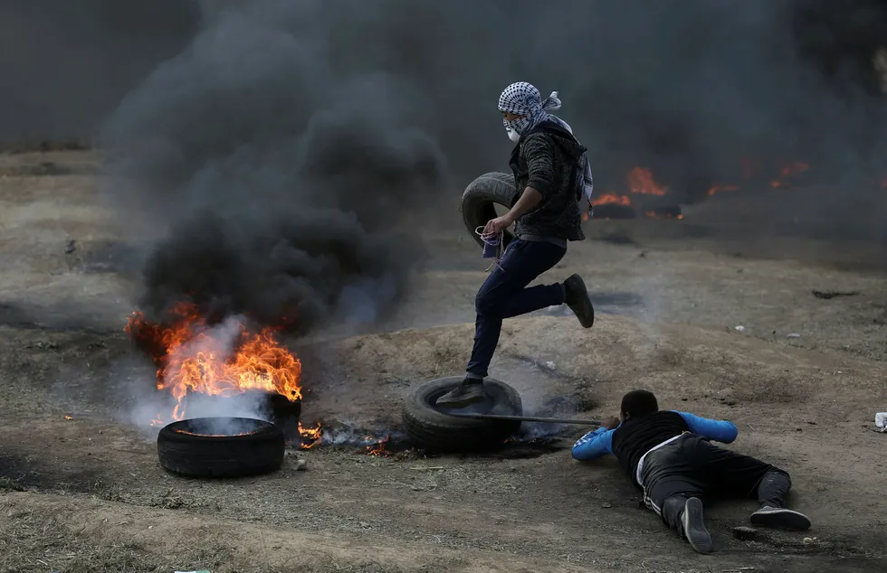 Palestinske demonstranter på Gazastripen satt mandag fyr på bildekk i et forsøk på å røyklegge områder nær grensen mot Israel og unngå å bli truffet av kuler fra israelske skarpskyttere. Foto: AP / NTB scanpix