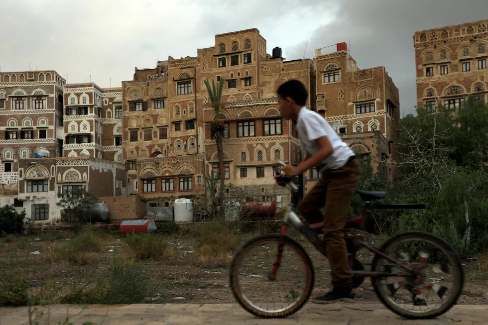 Declaration: a Yemeni boy rides his bicycle past old buildings in the historical quarter of the Yemeni capital Sana'a