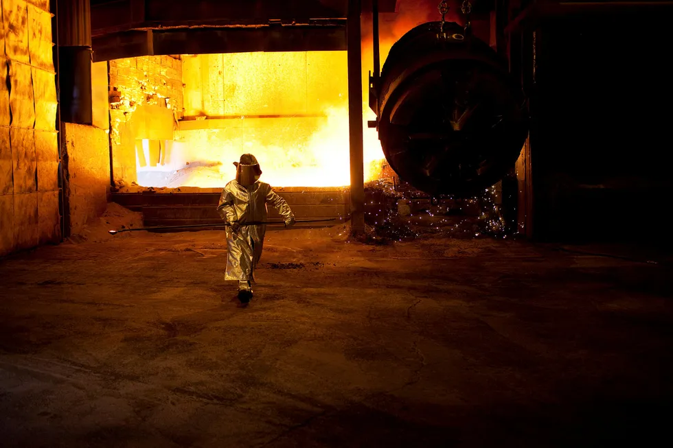 Varmeutstrålingen er formidabel når flytende mangan tømmes ved Sauda Smelteverk. En arbeider kledd i beskyttelsesdrakt henter ut en metallprøve for analyse. Foto: Tomas Larsen