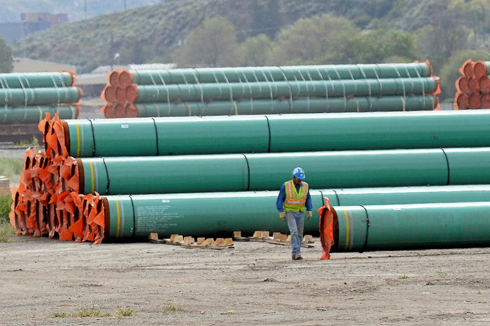 Resource base: a workman walks past steel pipe to be used for a Kinder Morgan pipeline project