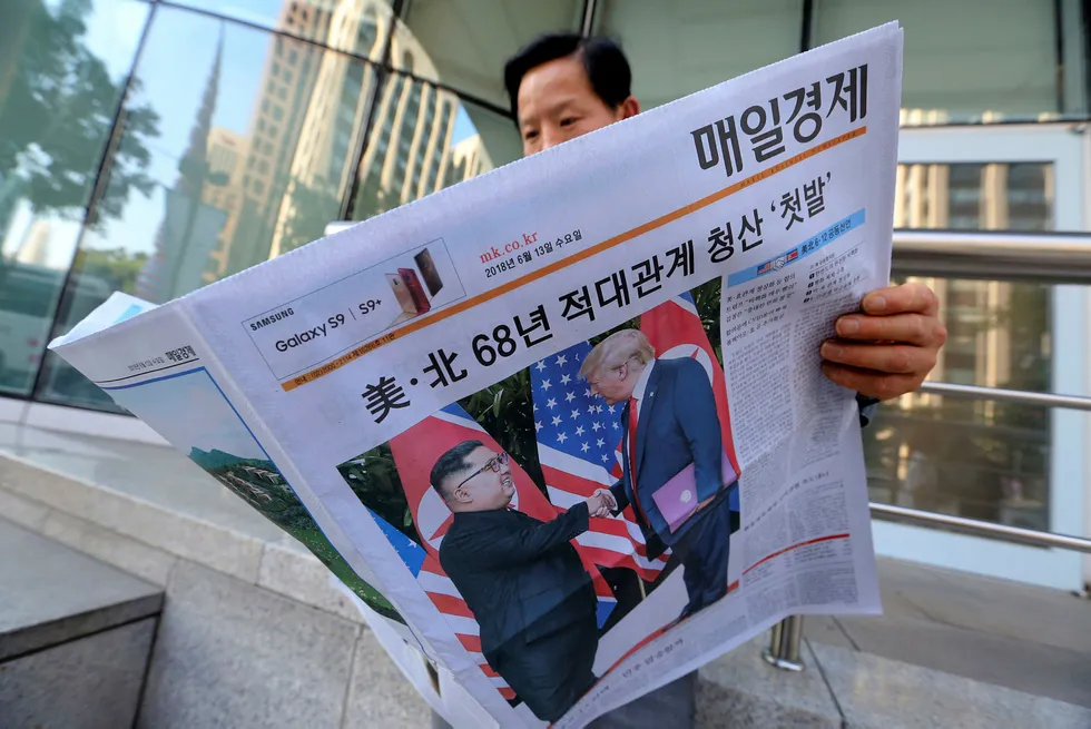 En man leser avisen som skriver om møtet mellom Kim Jong-un og Donald Trump. Foto: Ahn Young-joon/AP/NTB Scanpix