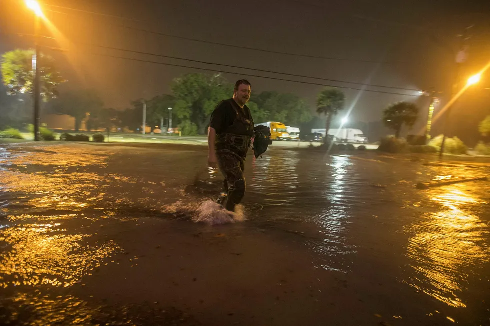 En mann vader igjennom en oversvømt strandvei idet sentrum av orkanen Nate nærmer seg Biloxi i Mississippi. Foto: MARK WALLHEISER/Getty Images/AFP/NTB Scanpix