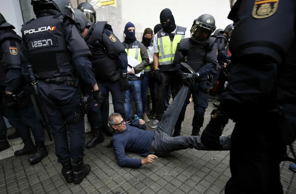 Spansk politi forsøker å komme inn til et stemmelokale i Barcelona søndag morgen. Foto: Pau Barrena/AFP Photo