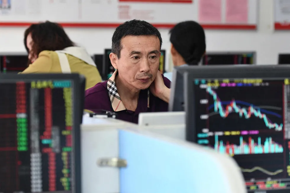 Investorer overvåker bevegelsene i aksjekursene ved et kinesisk verdipapirforetak i Fuyang.