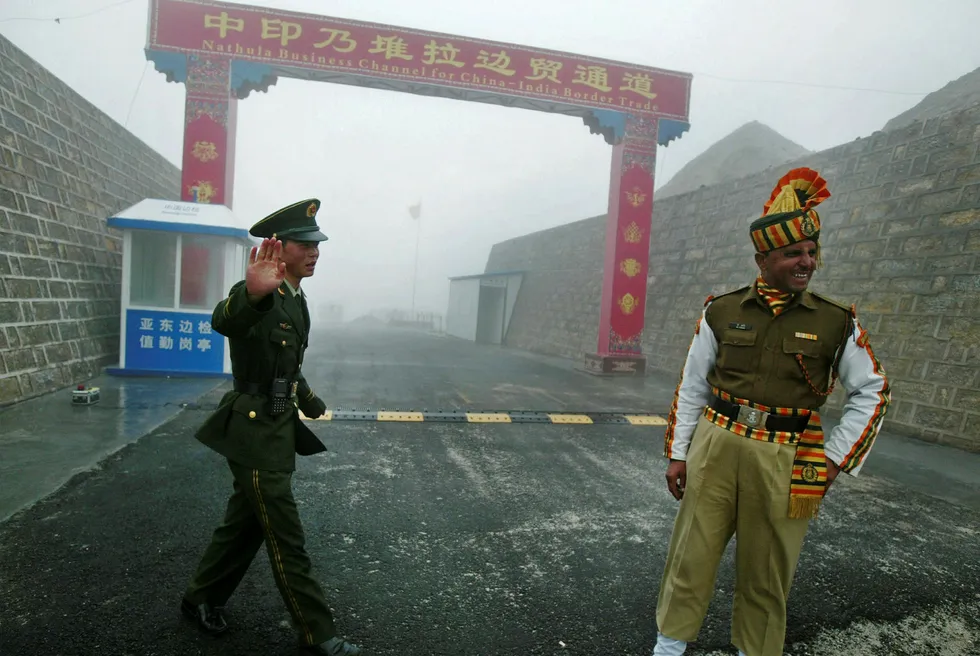 Kina anmoder India om å respektere inngåtte grenseavtaler. Bildet viser en kinesisk (til venstre) og indisk grensesoldat på den kinesiske siden av Nathu La-grensen mellom de to landene. Foto: Dipendu Dutta(AFP photo/NTB scanpix