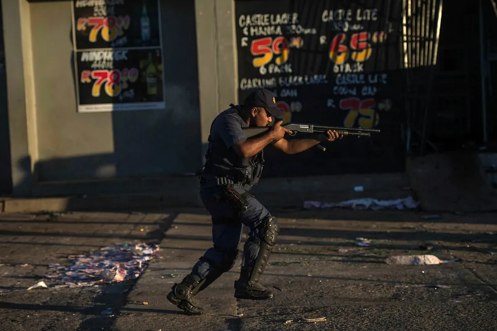 En sørafrikansk politimann skyter gummikuler for å stoppe plyndrere under sist ukes opptøyer i Mahikeng i Nordvest-provinsen i Sør-Afrika. Foto: Mujahid Safodien/AFP/NTB Scanpix