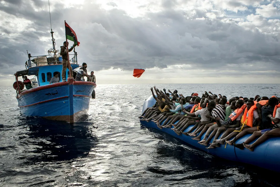 Bildet viser libyske fiskere idet de kaster redningsvester til flyktninger som ønsker å krysse Middelhavet i håp om et bedre liv i Europa. Foto: Mathieu Willcocks/AP/NTB Scanpix