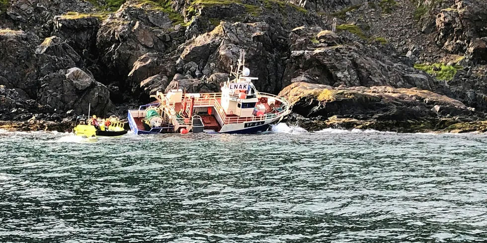 PÅ GRUNN: Fiskebåten «Lenangstind» gikk i morges på grunn ved Lyngstuva. Tre personer som var om bord ble berget av en fôr-fraktebåt.