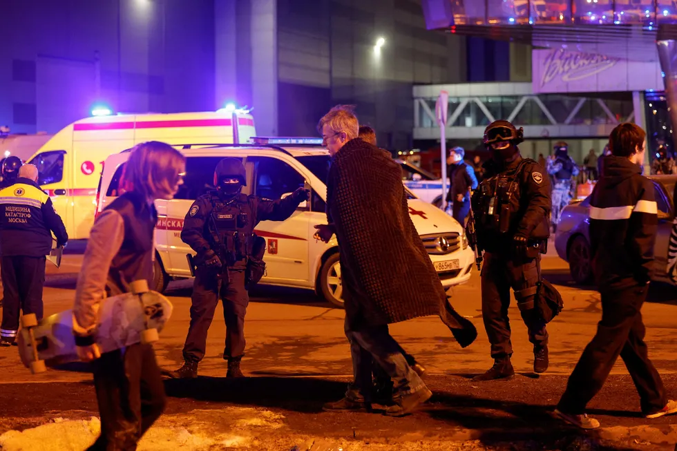 Mann som ble evakuert fra konserthuset etter skytingen. Russiske styrker leter etter gjerningspersonene etter angrepet.