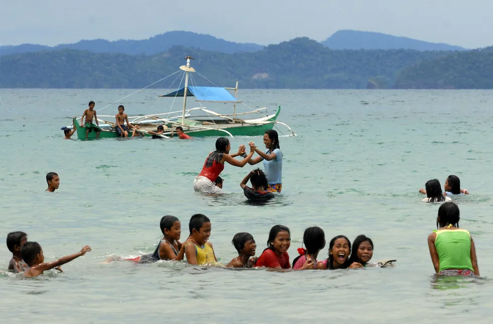 Offshore activities allowed: Filipino beachgoers enjoy the clean and unpolluted waters of Sabang beach on the island of Palawan in the Philippines