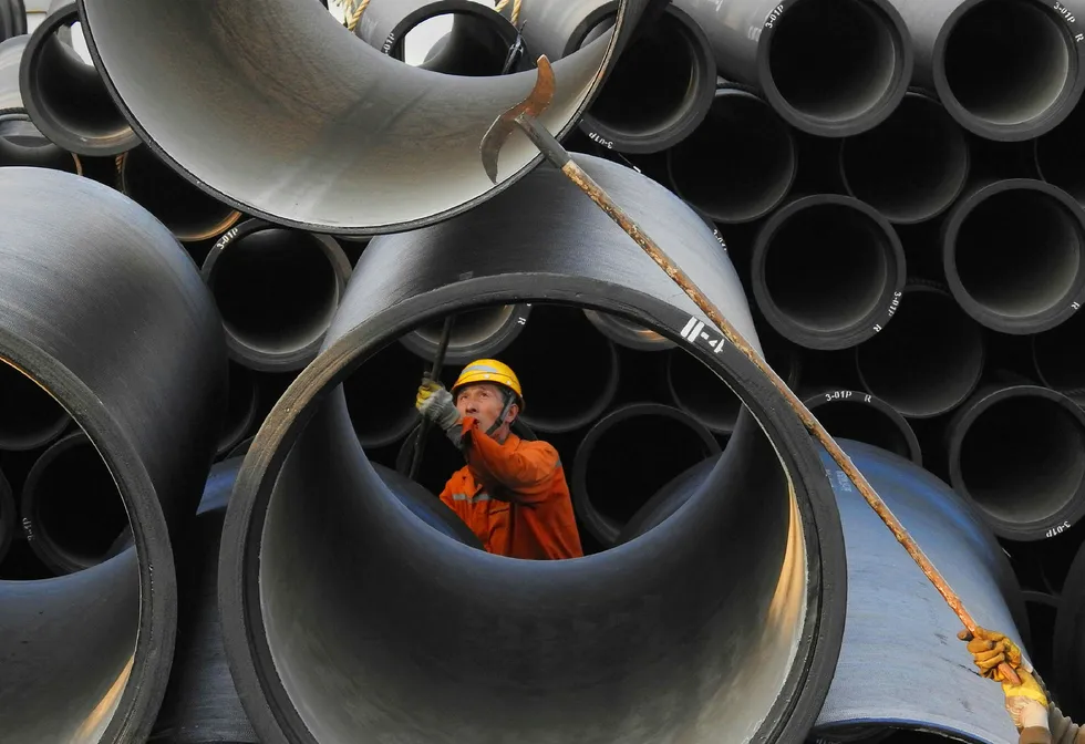 Verdensøkonomien går for full maskin. Både USA, Europa og Kina har solid økonomisk vekst – samtidig, for første gang siden 2008. En arbeider tar imot rør på havnen i Lianyungang i Kina. Foto: AFP/NTB Scanpix