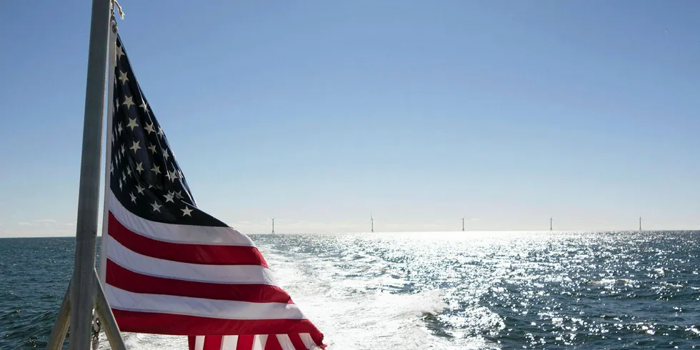 A US flag flies in front of the completed Block Island wind farm, off Rhode Island