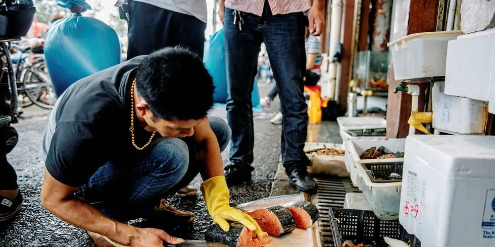 BRØT AVALTE: Når norske fiskeeksportører bryter avtalen om å ikke eksportere laks med ILA smitte, får det store konsekvenser for norsk eksport til landet. Her er en fiskehandlere på fiskemarkedet i Shanghai. Foto: Fartein Rudjord