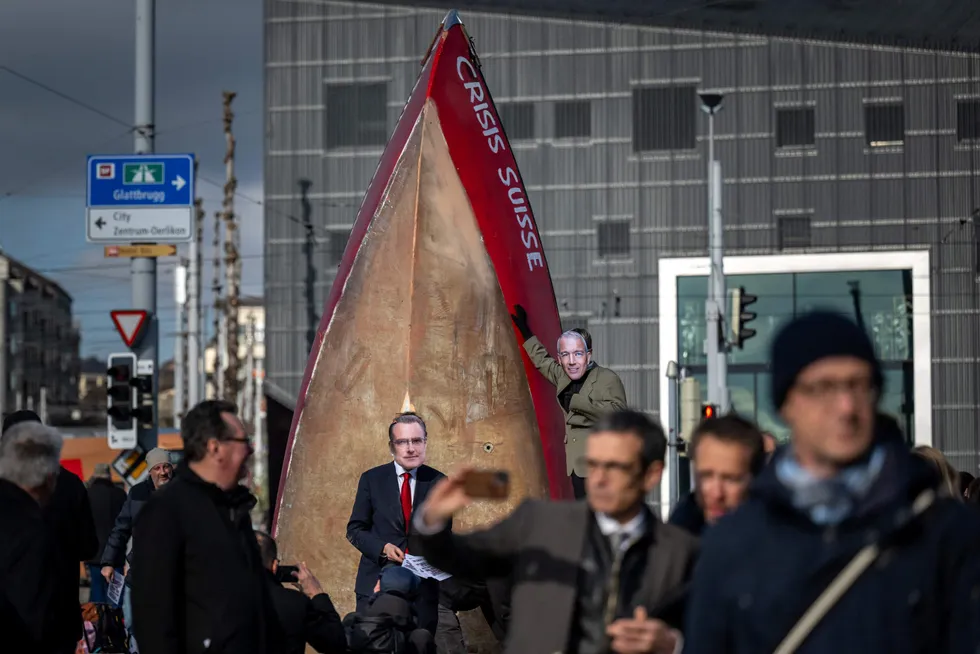 Klimaaktivister med masker som forestiller Credit Suisses styreleder Axel Lehmann og sentralbanksjef Thomas Jordan har møtt opp utenfor bankens generalforsamling i Zürich tirsdag formiddag.