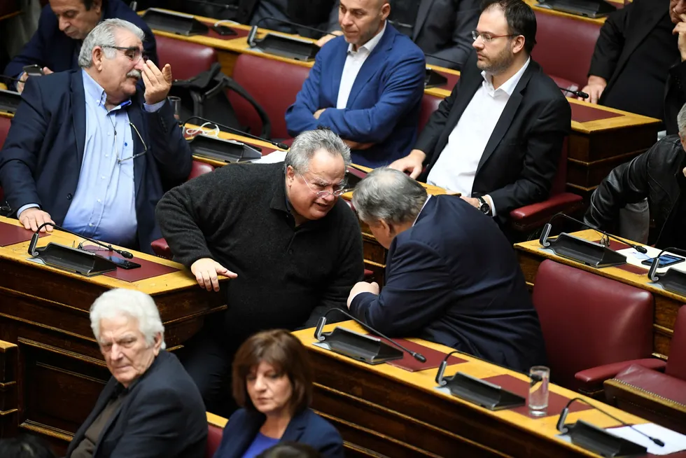 Den tidligere greske utenriksministeren Nikos Kotzias snakker med tidligere visestatsminister og finansminister Evangelos Venizelos under en debatt i det greske parlamentet fredag.