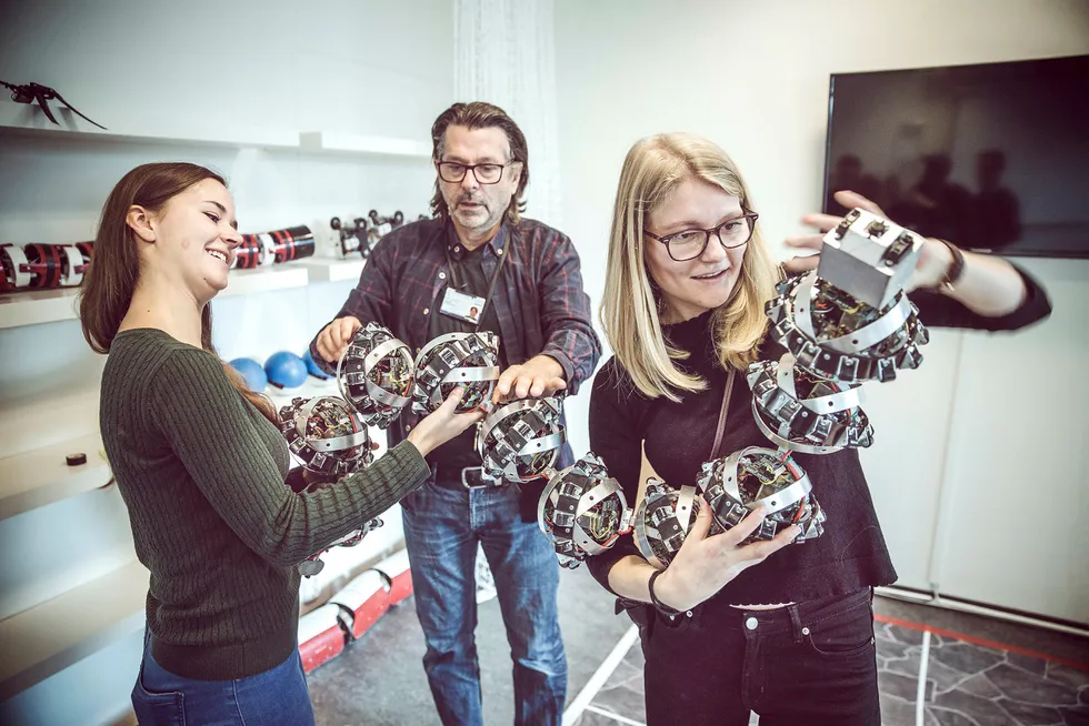 Kybernetikk-studentene går lyse jobbtider i møte. Marie Strømme Kristiansen (fra venstre), teknisk leder Stefano Bertelli og Camilla Sterud studerer her en robotslange, som blant annet kan utføre kronglete oppgaver på havbunnen. Foto: Øyvind Nordahl Næss