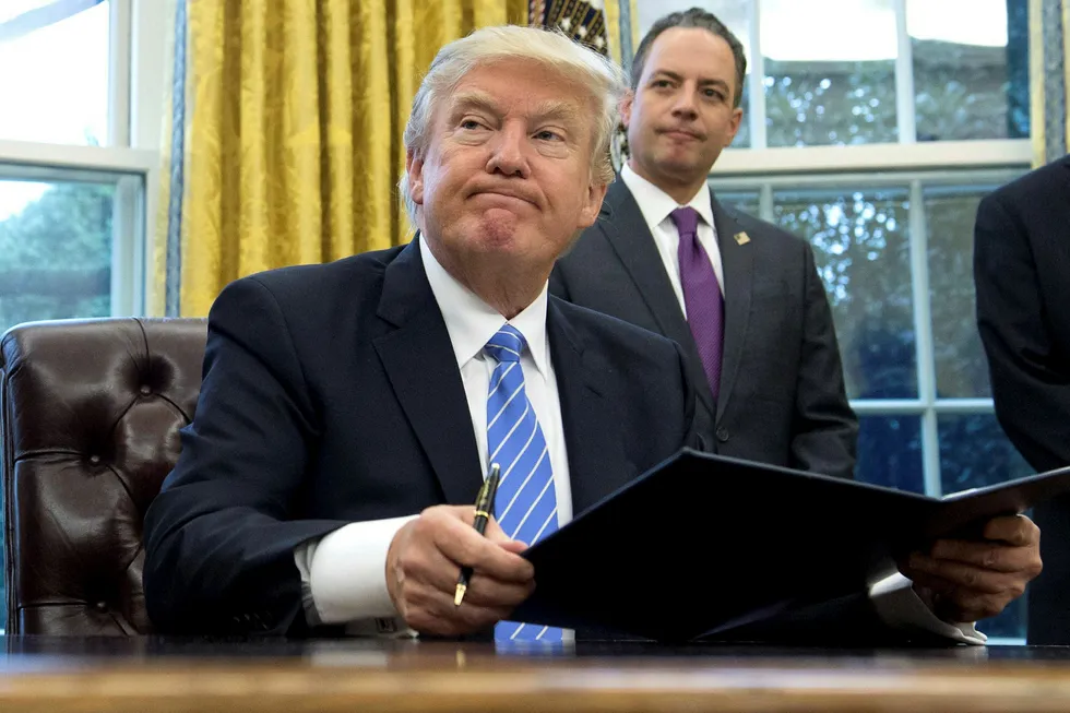 USA president Donald Trumps første arbeidsdag som president mandag. Stabssjef Reince Priebus i bakgrunnen. Foto: SAUL LOEB/Afp/NTB Scanpix