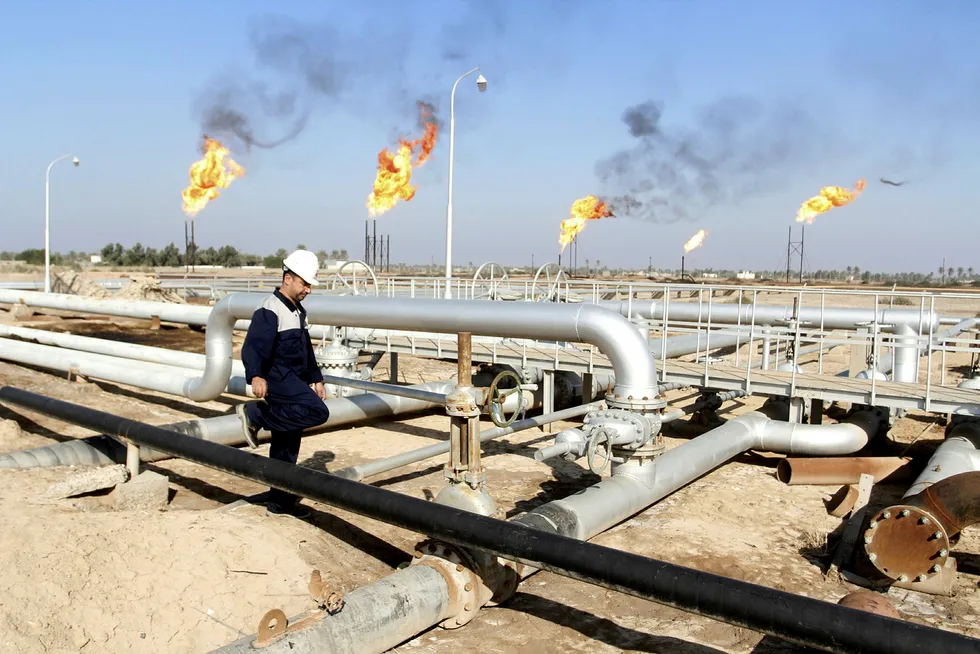 En arbeider går i mellom oljerørledninger på oljefeltet Nahr Bin Umar i Irak. Foto: Essam Al Sudani/Reuters/NTB Scanpix