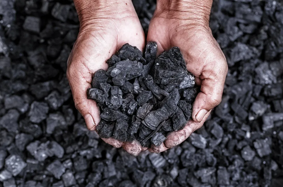A miner with a handful of coal.