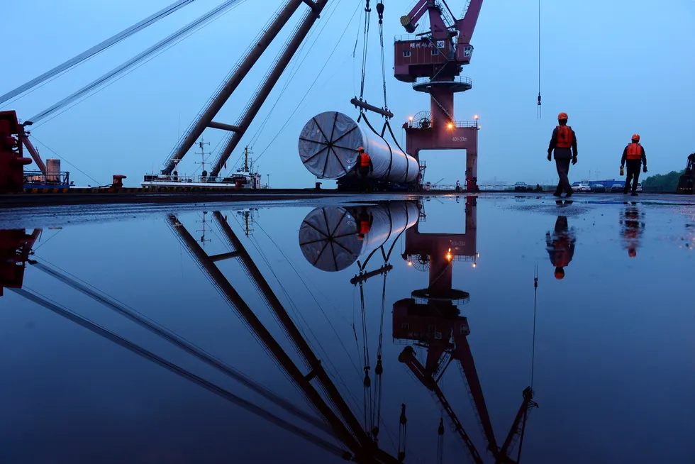 Building: a crane lifting offshore wind energy equipment at a port in Nanjing, China.