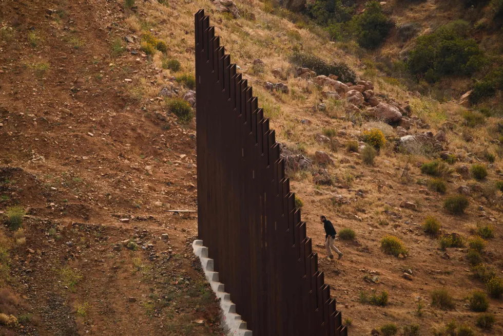 Barrier: a Mexican official walks to the end of an incomplete new section of the wall on the US-Mexico border. One seismic company has found work with the US Customs & Border Protection on the controversial project