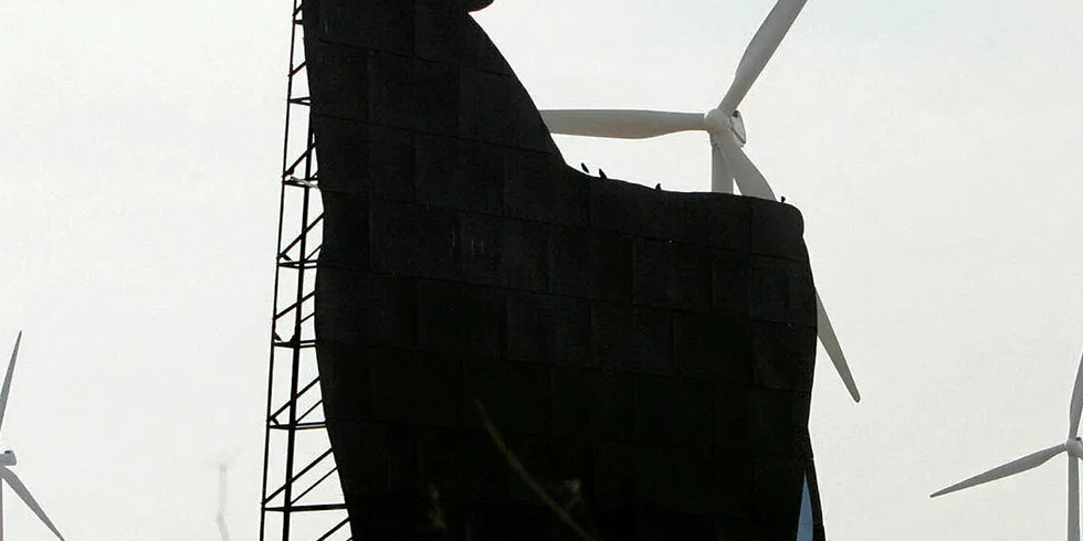 An Osborne bull in front of wind turbines near Zaragoza.