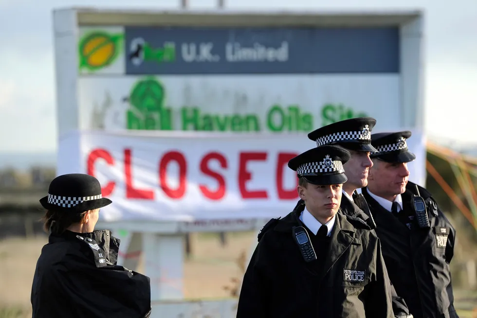 Protest: police stand near a defaced Shell sign on a road leading to the Coryton refinery in Stanford Le Hope outside London, in 2010