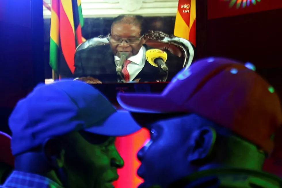 Folk på en par i Harare fikk med seg Robert Mugabes tale søndag kveld. Foto: Philimon Bulawayo / Reuters/ Scanpix